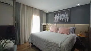 Quarto com cama e cortinas brancas na sala.