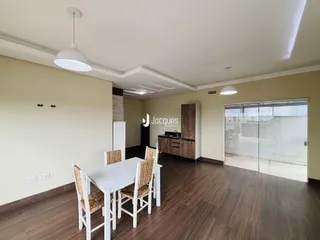 Ambiente interno de sala de jantar com piso de madeira e mesa branca.