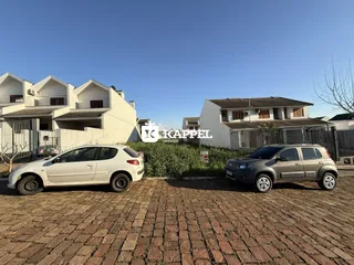 Foto da fachada de uma residência em Lajeado, Brasil, com dois carros estacionados na frente.
