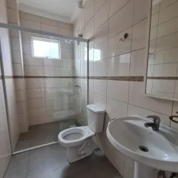 Foto de um banheiro com paredes revestidas de azulejos brancos.