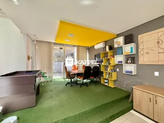 Esta é uma sala de estar com área de jantar e estantes decorativas.
