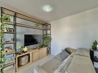 Sala de estar com sofá e estante de madeira em um imóvel no Brasil.