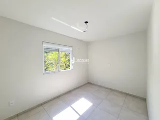 Interior de uma sala com paredes brancas e piso de cerâmica.