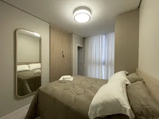 Quarto com cama e espelho em um imóvel no Brasil.