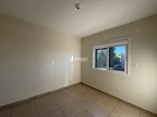 Foto do interior de uma sala com piso de cerâmica clara.