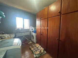 Quarto com armários de madeira e janela em um imóvel no Brasil.