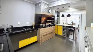 Vista da cozinha moderna com armários amarelos e bancadas escuras.