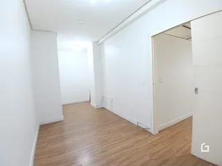Hall de corredor com piso de madeira clara.