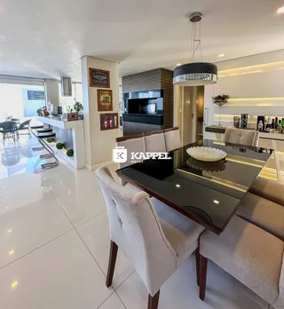 Foto de um ambiente de jantar moderno com mesa de vidro e cadeiras em um apartamento.