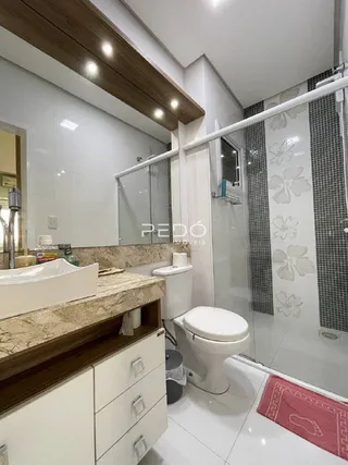 Foto de um banheiro com revestimento branco e box de vidro.