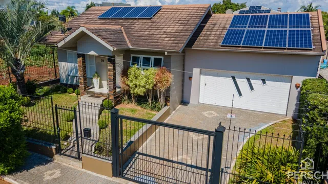 Fachada de uma casa residencial em Lajeado, Brasil, com telhado e painéis solares visíveis.