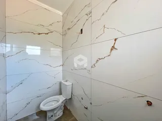 Foto de um banheiro com revestimento de mármore nas paredes.