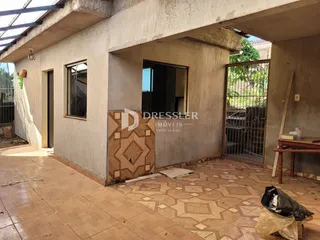 Vista interna de uma área com paredes de concreto e piso de cerâmica em construção.