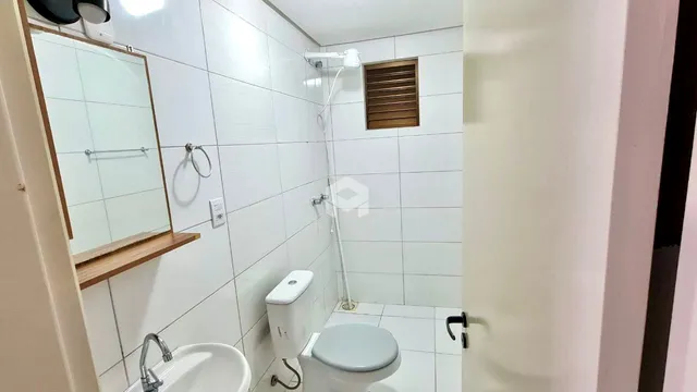Foto de um banheiro com azulejos brancos e vaso sanitário.
