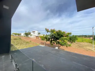 Vista da propriedade com área externa e vegetação ao fundo.