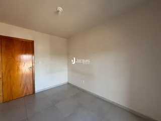 Ambiente interno de uma sala com piso de cerâmica e porta de madeira.
