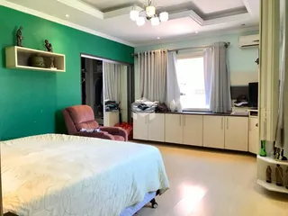 Quarto com parede verde e cama grande em um imóvel no Brasil.