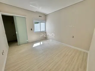 Ambiente interno de uma sala com piso de madeira clara.