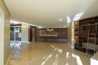Sala de estar com piso claro e painel de madeira na área interna.