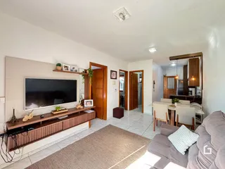Sala de estar com televisão e móveis de madeira em um imóvel no Brasil.