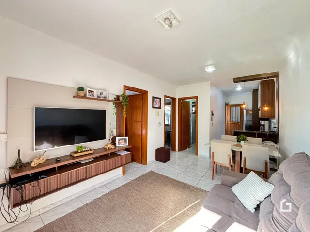 Sala de estar com televisão e móveis de madeira em um imóvel no Brasil.