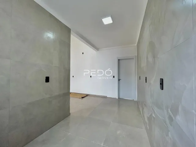 Hall de entrada com paredes cinzas e piso claro em imóvel no Brasil.