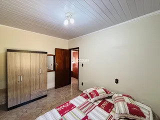 Quarto com armário de madeira e cama no interior de uma residência.