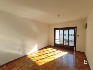 Sala de estar com piso de madeira e luz natural entrando pela janela.