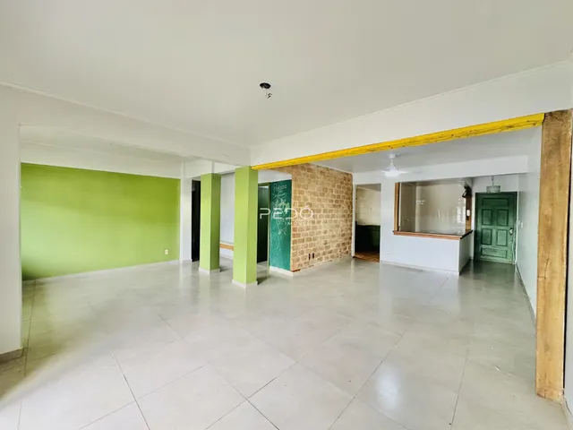 Vista de um ambiente interno amplo com paredes verdes e piso de cerâmica.