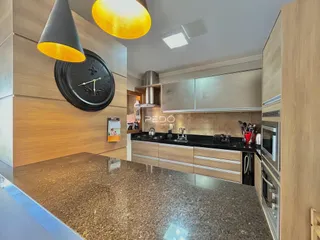 A cozinha moderna apresenta armários e bancadas em tons neutros.