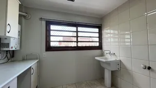 Foto de um banheiro com azulejos brancos e uma janela.