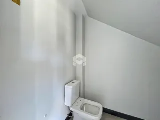Foto de um banheiro interno com vaso sanitário branco.