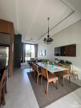 Uma sala de jantar com mesa e cadeiras em um ambiente claro.