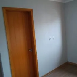 Foto de uma porta de madeira em um interior com paredes brancas.