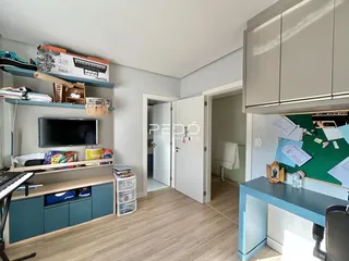 Sala de estar com estantes e piso de madeira clara.
