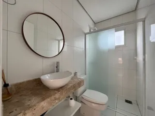 Foto de um banheiro moderno com bancada de mármore e box de vidro.