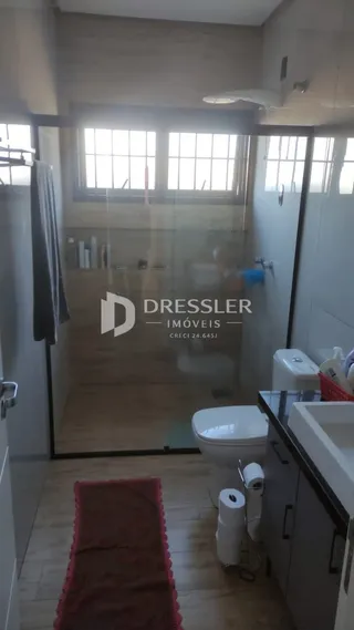 Foto de um banheiro com vasos sanitários brancos e piso de madeira.