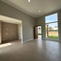 Foto de um ambiente interno com paredes claras e uma grande janela.