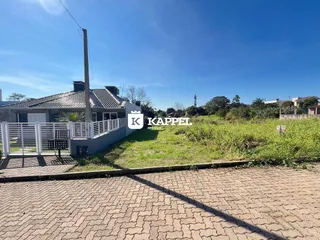 Foto da fachada de uma residência com cerca branca e área gramada.