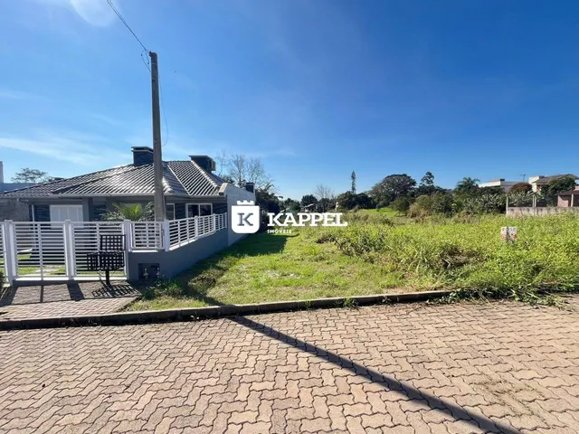 Foto da fachada de uma residência com cerca branca e área gramada.