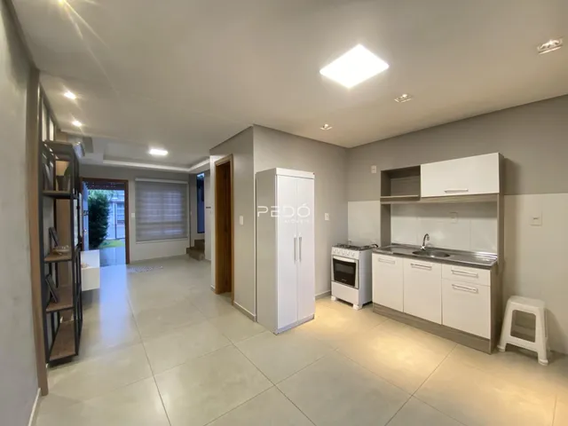 Interior de uma sala de estar e cozinha em um imóvel no Brasil.