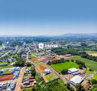 Vista aérea de um loteamento residencial com áreas verdes e construções na região de Lajeado.