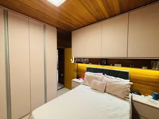 Quarto com cabeceira de madeira e armários embutidos.