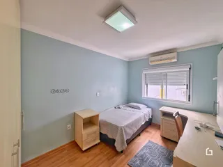 Quarto com paredes azul claro e piso de madeira.