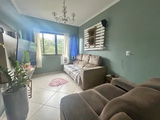 Sala de estar com paredes verde-água e grandes janelas.