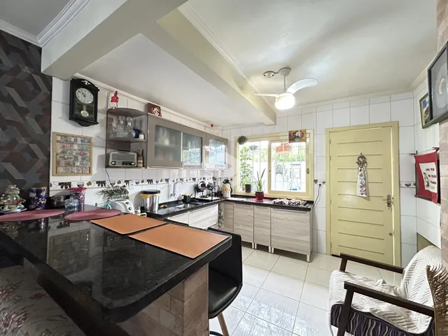 Imagem de uma cozinha com armários e bancada em um imóvel no Brasil.