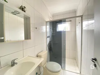 Banheiro com revestimento cerâmico branco.