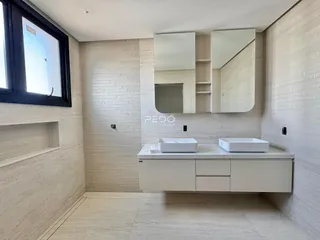 Banheiro com revestimento de azulejo branco e bancada moderna.