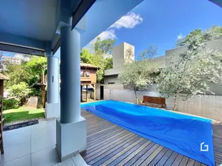 Piscina externa com deck de madeira em uma residência.
