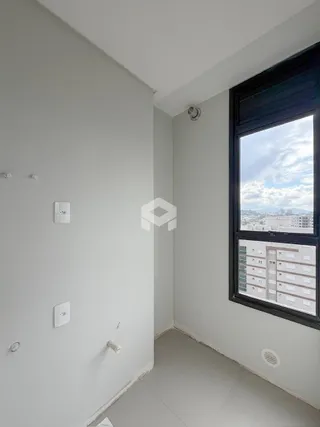 Vista de um canto de cômodo interno com paredes brancas e piso claro.